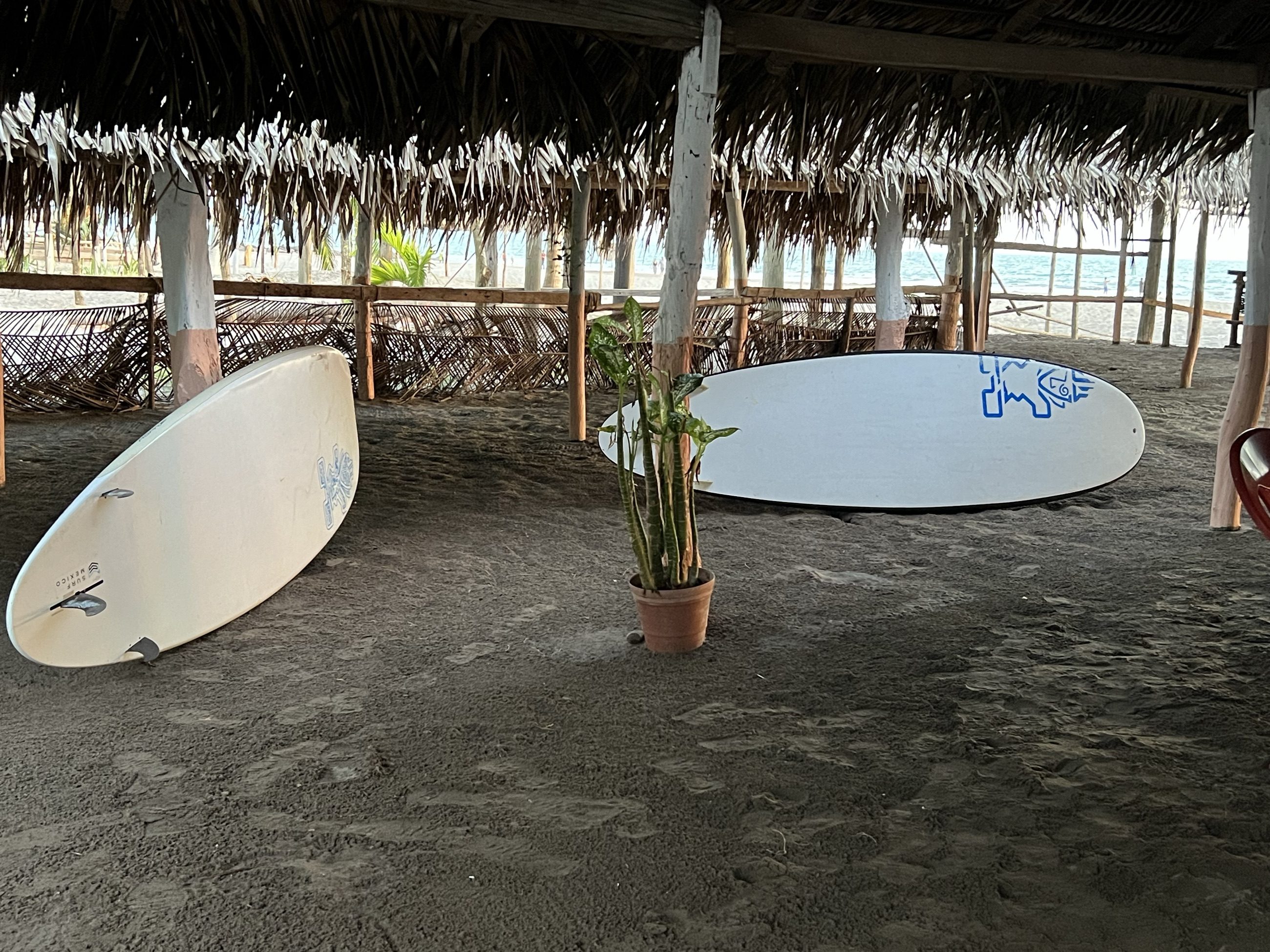 Dos tablas largas paradas bajo una palapa de palma