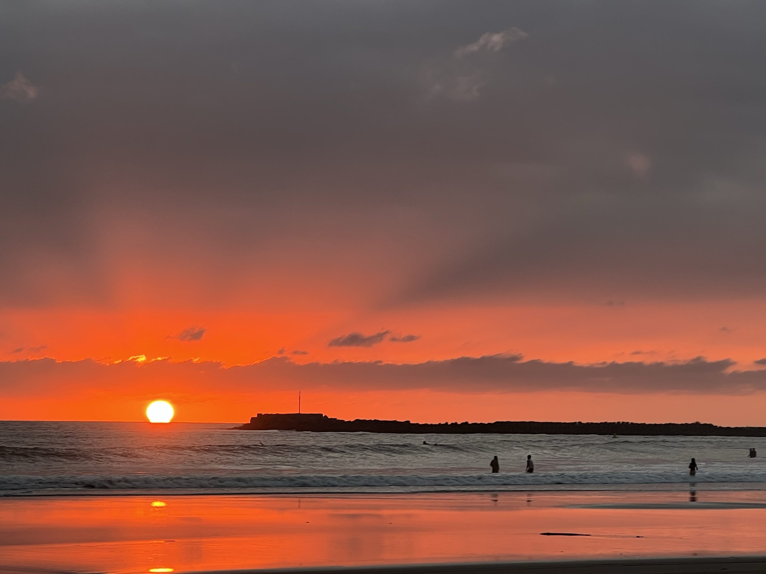 Atardecer encendido sobre una playa abierta y vacía